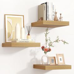 two wooden shelves with vases, books and pictures on them against a white wall