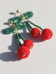 red and green beaded cherries hanging from strings