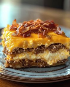 a piece of cheese and bacon layered dessert on a blue plate with a wooden table in the background