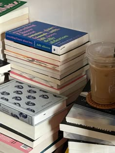 a stack of books sitting on top of each other next to a cup of coffee