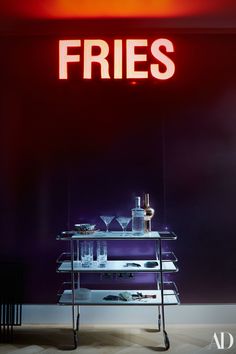 a bar cart with drinks on it in front of a sign that says fries