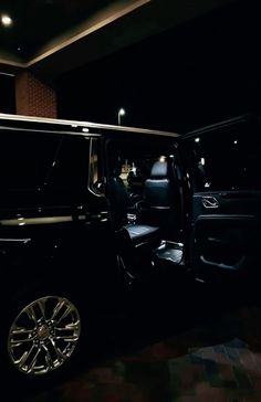 the interior of a luxury vehicle with its door open in a dark room at night