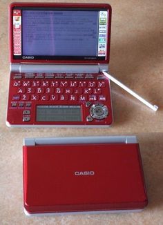 a red laptop computer sitting on top of a table next to a pen and mouse