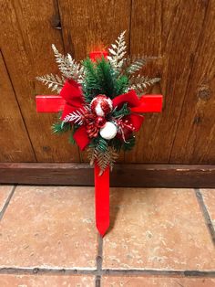 a red ribbon tied to the side of a door decorated with greenery and balls