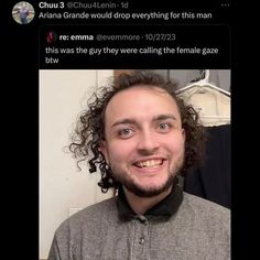 a man with curly hair is smiling for the camera