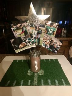 a football themed centerpiece on top of a table with photos and cards in it