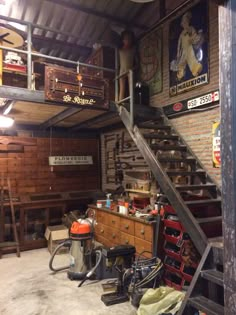 there is a man standing on the stairs in this garage with tools and other items