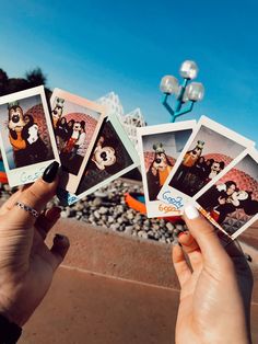 a person holding up four polaroid photos in front of a building