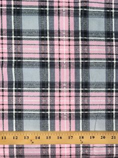 a pink and black plaid fabric with a ruler on the bottom right hand side that is measuring