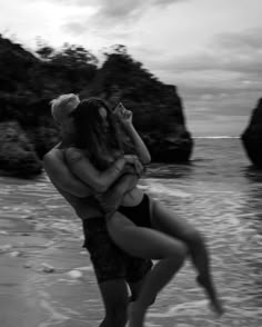 a man and woman hug on the beach