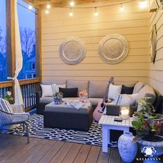 an outdoor living area with patio furniture and string lights