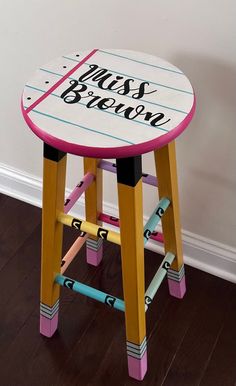 a wooden stool with writing on it