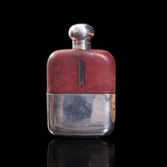 a red and silver flask with a black background