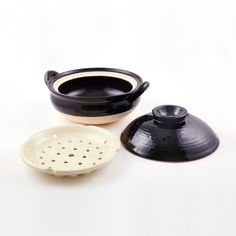 two black and white bowls with lids next to each other