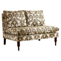 an ornate patterned couch with wooden legs