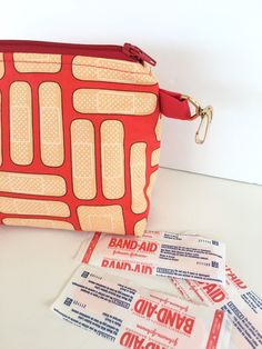 an image of a red bag with bandages on the side and some packets in front