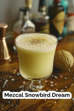 a drink in a glass sitting on top of a wooden table