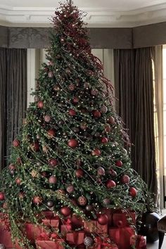 a christmas tree with presents under it in a living room decorated for the holiday season