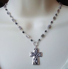 This fabulous cross necklace can be worn in many occasions. The classic style make these necklace timeless. This beautiful pendant necklace features a detailed sculpted cross. Pendant is made of pewter metal and plated in sterling silver. Cross pendant hangs from a hand made chain consist of sculpted metal castings and hematite crystals. This simple yet striking necklace is finished with a spring ring clasp. The necklace measures 16 inch in length, with 2 inches extension. Cross pendant is sculpted on both side.  This beautiful pendant necklace are unique, feminine and eye-catching, a perfect accent for a special event or a special gift to someone you love.  Cross pendant is 1.75 inches in length. Beaded Spiritual Cross Pendant Necklace, Silver Cross-shaped Jewelry With Beaded Chain, Silver Cross Jewelry With Beaded Chain, Spiritual Beaded Cross Pendant Jewelry, Spiritual Cross Necklace With Beaded Chain, Beaded Cross Pendant For Jewelry Making, Elegant Cross Necklace With Beaded Chain, Gothic Beaded Cross Jewelry, Bohemian Beaded Cross Pendant Jewelry