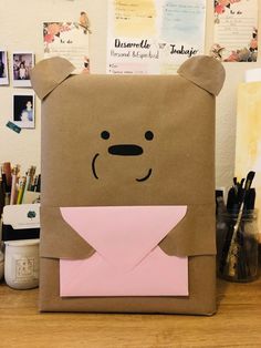 a brown paper bag with a pink envelope in the shape of a bear