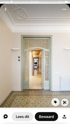 an open door leading to a hallway with white walls and floor tiles on the ground