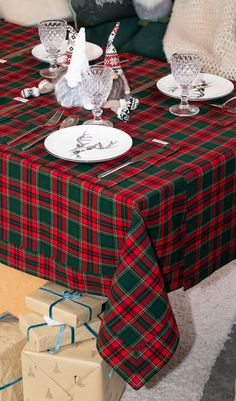 the table is set for christmas dinner with presents