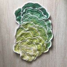 a crocheted broccoli dishcloth on a wooden surface