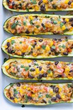 four stuffed zucchini boats with black beans, cheese and cilantro