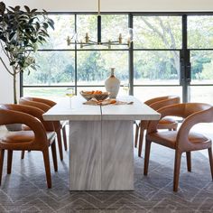 a dining room table with chairs around it and a vase sitting on top of the table