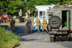 men in uniforms are walking down the street