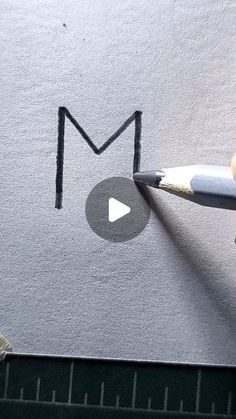 someone is drawing the letter m with pencils