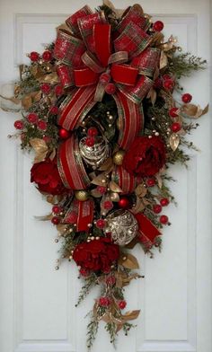 a christmas wreath hanging on the front door with bells and ornaments around it's perimeter