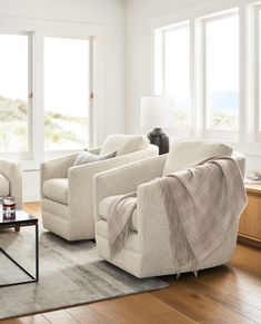 a living room with two couches and a cat sitting on the armrests