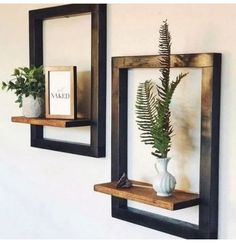 there are two wooden shelves with plants on them and one is holding a framed photo