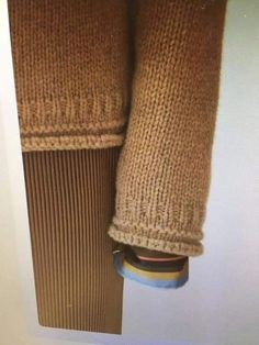 a pair of brown knitted gloves hanging on a wall