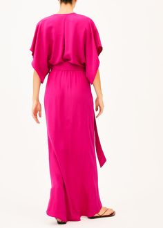 The Norma is a low v neck pink full length dress that features a plunging neckline with two concealed snaps to change the length of the neckline, half split sleeves, an elastic waist with a long wrap belt, and an asymmetrical skirt. This elegant silhouette is perfect for any formal event. Our pieces are majority made to order ensuring that no fabric is wasted and energy is conserved. Once the order is placed we will notify you when it has been made and is shipped out (Approximately 2-3 weeks). C Pink V-neck Dress With Surplice Neckline For Formal Occasions, Pink Belted V-neck Midi Dress, Pink V-neck Surplice Dress For Formal Occasions, Pink V-neck Surplice Neckline Formal Dress, Elegant Pink Wrap Dress, Formal V-neck Belted Maxi Dress, Formal Belted V-neck Maxi Dress, Spring Pink Maxi Dress With Side Slits, Chic Belted Maxi Dress With Surplice Neckline