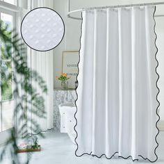 a white shower curtain with black scalloped trim and a round mirror above it