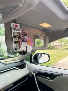 the inside of a car with pictures and magnets attached to it's dash board