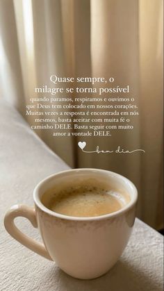 a cup of coffee sitting on top of a table next to a window with the words que sempre, milgre se torra possoveli