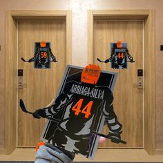 an image of a hockey player holding up a sign in front of two doors with stickers on them