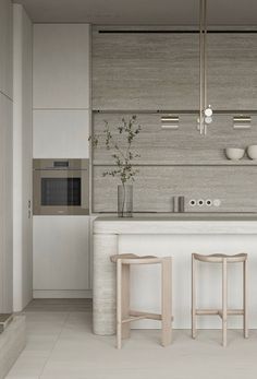 a white kitchen with two stools next to the counter