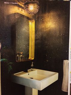 a white sink sitting under a bathroom mirror next to a green plant and light fixture