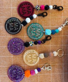 several different key chains are laid out on the floor next to some buttons and beads