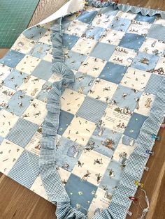 a blue and white quilt laying on top of a wooden floor