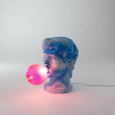 a blue and pink statue with a bubble coming out of it's mouth, on a white background