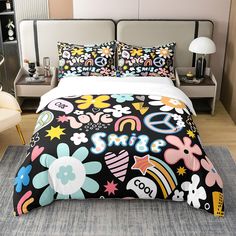 a bed covered in black and white comforter with colorful designs on it's cover