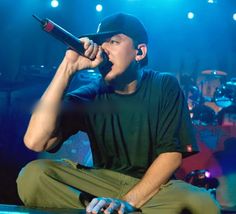 a man sitting on top of a stage holding a microphone