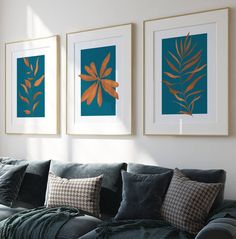 three framed pictures hang on the wall above a couch in a room with blue and green decor