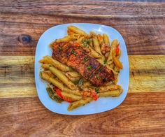 a white plate topped with meat and french fries on top of a wooden table next to a cutting board