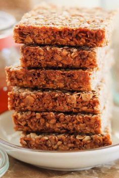 five granola bars stacked on top of each other in front of a glass jar